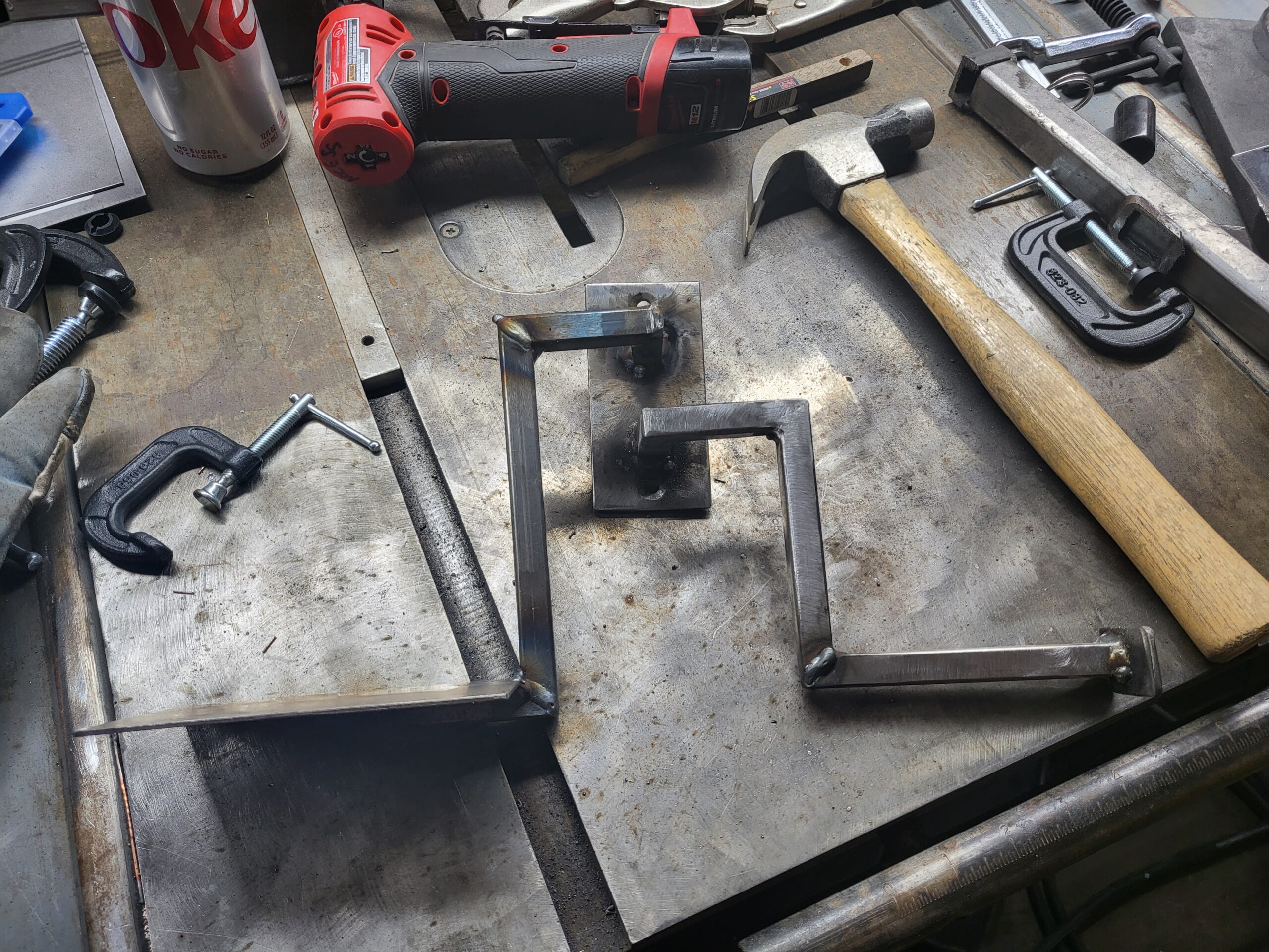 ToofBrush N Towel mark's badass workshop bench with a hammer and a custom bathroom toothbrush and towel holder made of steel.